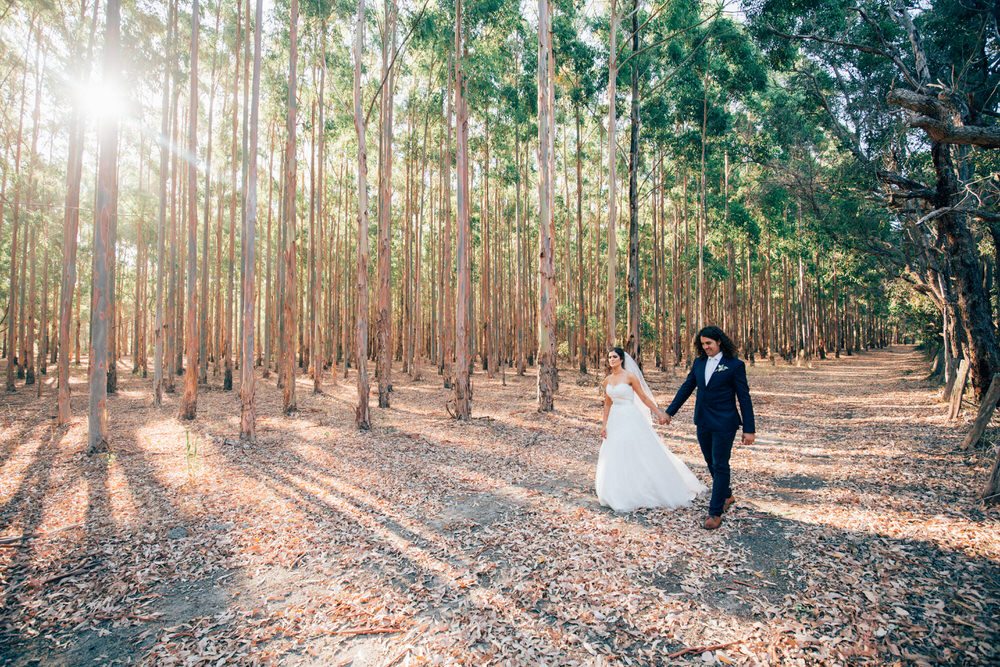 bride and groom walking in the bush