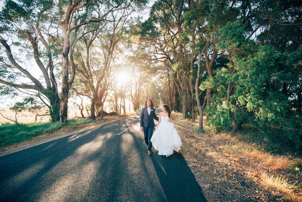 Bride and groom walking on road