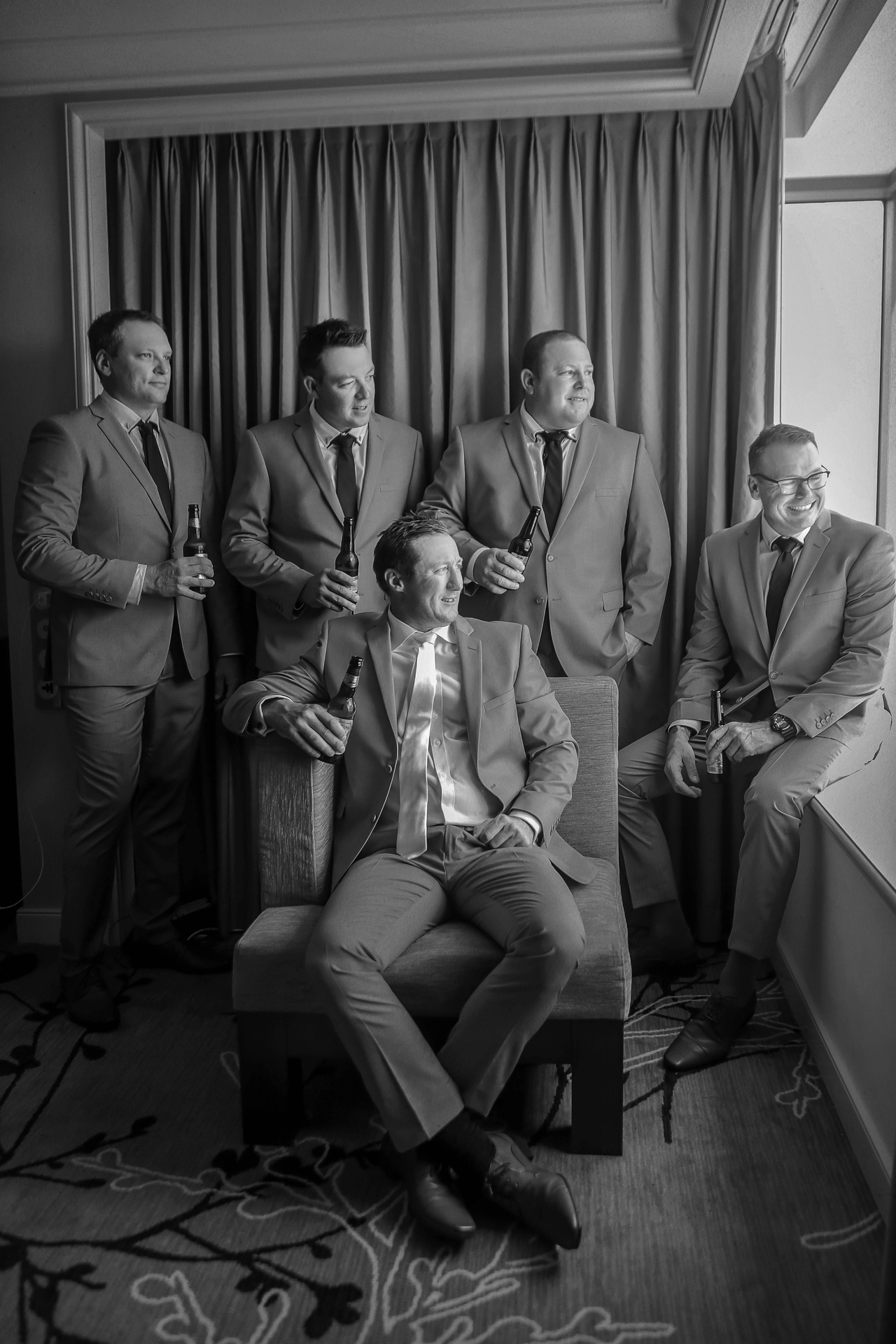 The groom sitting with his groomsmen