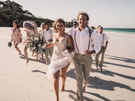 bride and groom walking on the sand