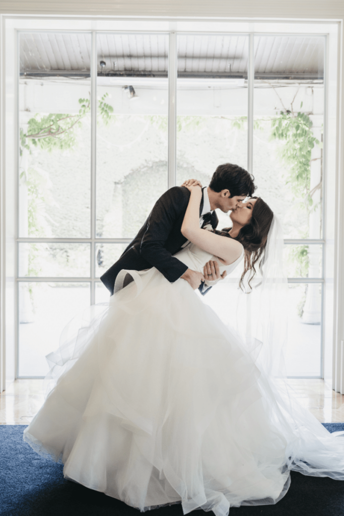The couple sharing a kiss at their wedding venue