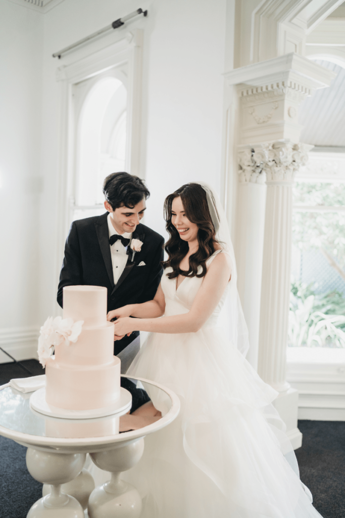 The newly weds slicing their three-tier wedding cake
